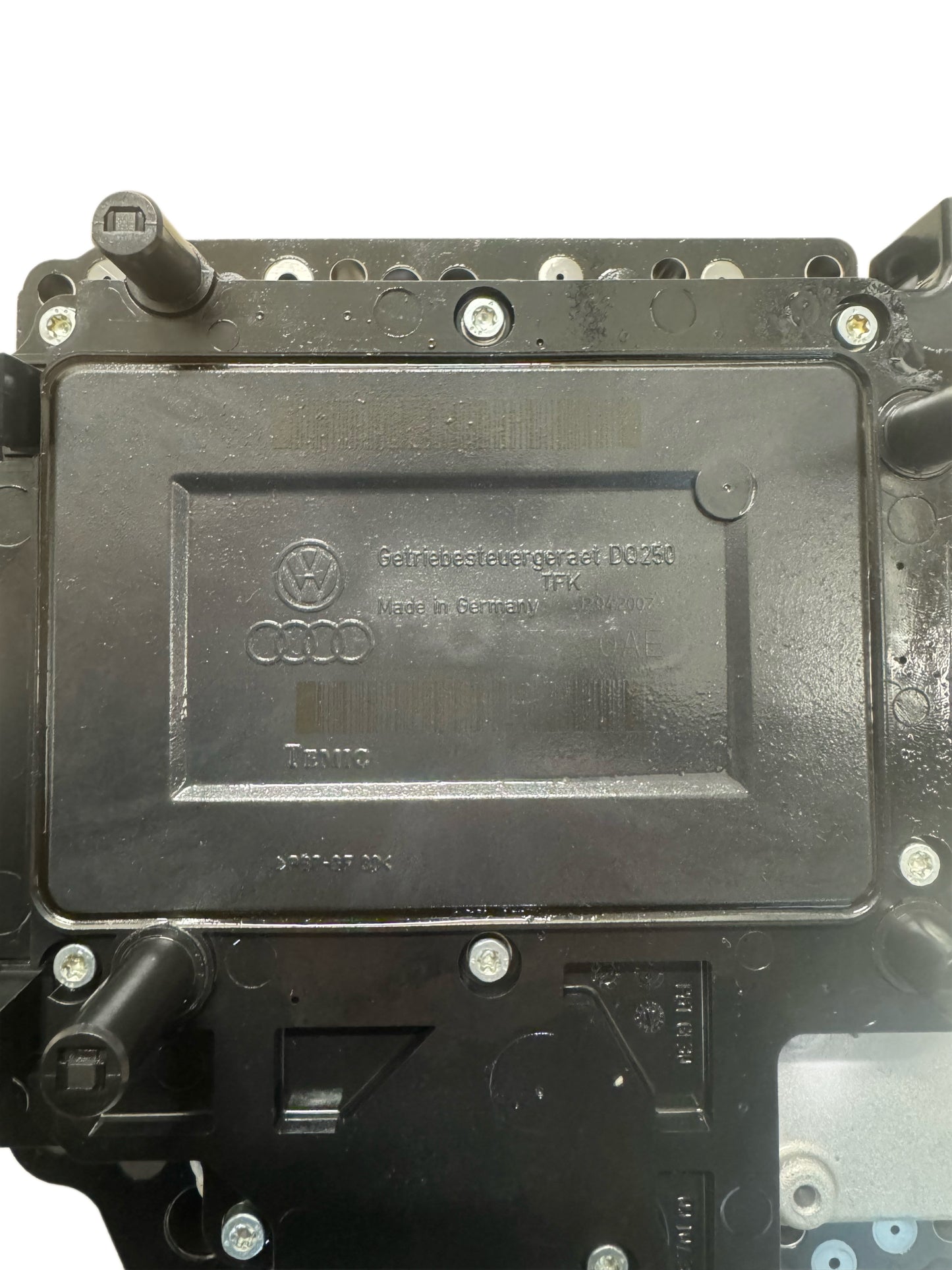 02E927770AE DSG DQ250 mechatronics top label view showing Volkswagen Group logo, Audi rings logo, Getriebe label DQ250, Made in Germany, TEMIC manufacturer marking, and hydraulic connector ports