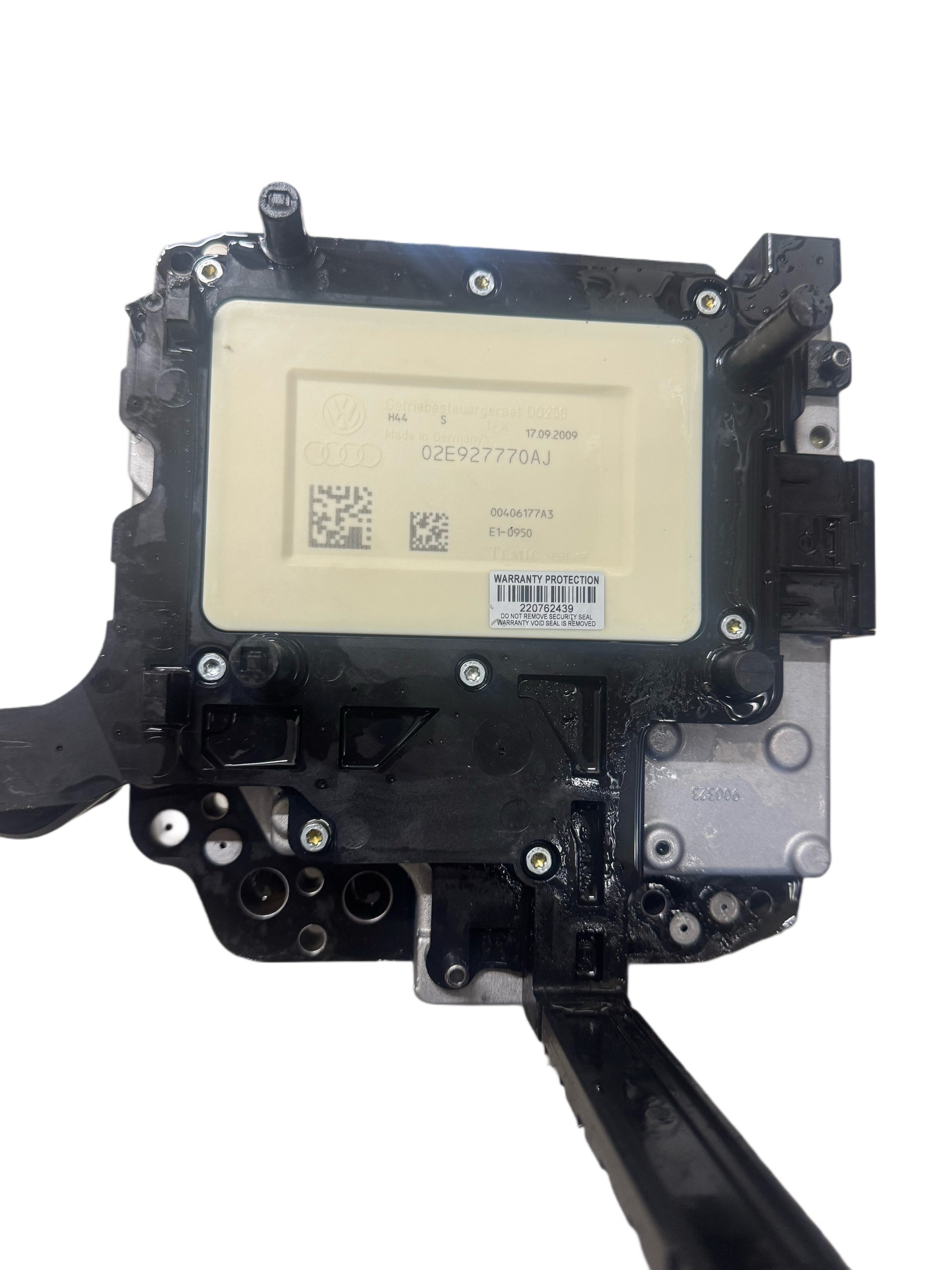 02E927770AJ DSG DQ250 mechatronics control unit top view showing part number label, TEMIC manufacturer marking, QR codes, production date 17.09.2009, and warranty protection sticker